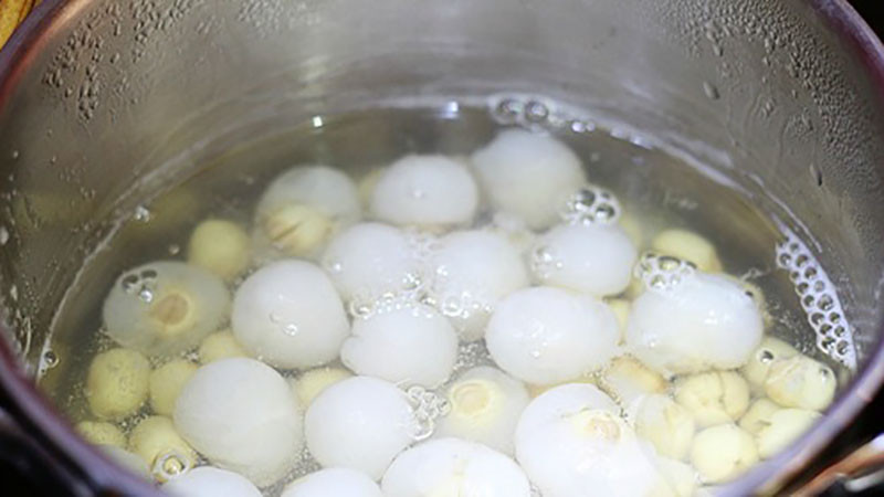 alt: Chè vải hạt sen đang được nấu trên bếp