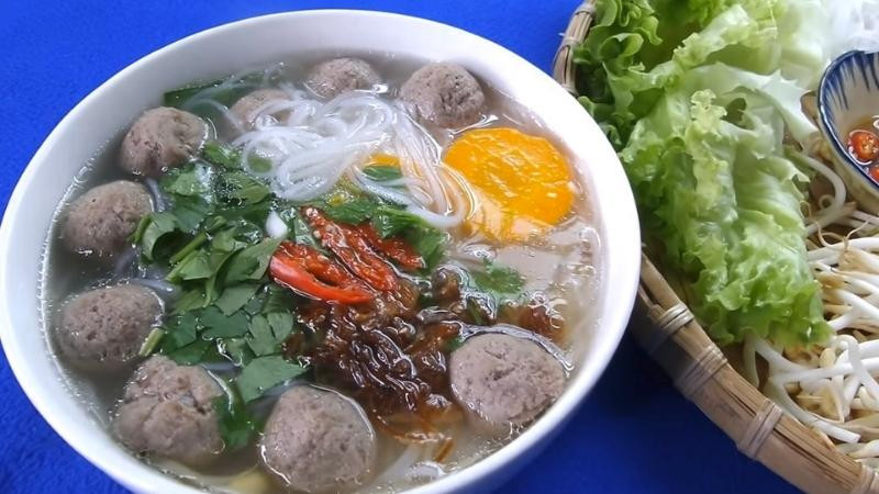 alt text: Thưởng thức tô hủ tiếu bò viên cùng tương ớt và tương đen