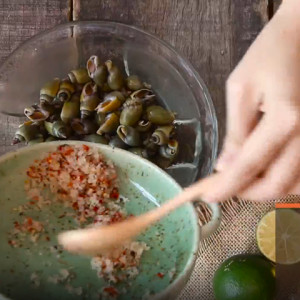 Món ốc cà na rang muối thưởng thức cùng rau răm